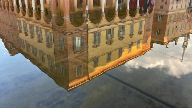 Reflections of historical buildings on the water pool fountains in Modena