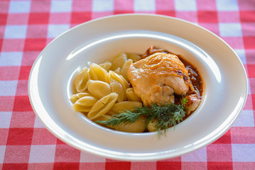 Macaroni pasta with bolognese sauce and parmesan cheese with a piece of meat on a white plate isolated.