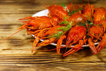 Boiled crayfish in plate on wooden table