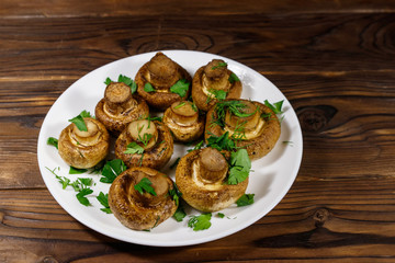 Baked mushrooms in plate on wooden table