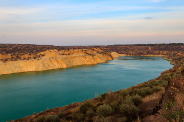 View of a lake with sandy shores in flooded sand quarry