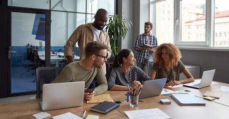 Teamwork. Group of young happy multicultural business people working together in modern office,...