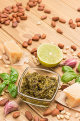 Ingredients for homemade pesto. Parmesan cheese, pesto sauce in glass cup.  Lemon and basil and oil. Garlic and pine nuts.