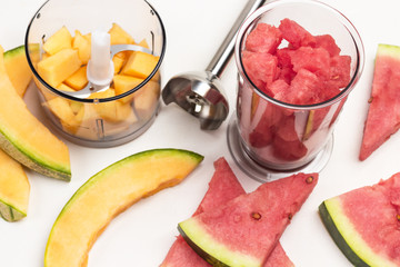 Slices of watermelon and melon. Pieces of melon and watermelon in blender jar. Metal blender.