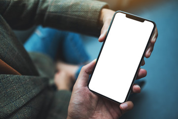Mockup image of a woman holding and showing mobile phone with blank white desktop screen to someone