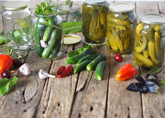 The process of preserving cucumbers in glass jars under lids for storage for the winter.Jars of...