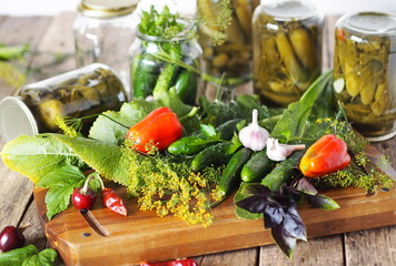 Jars with cucumbers, ingredients for pickling on a wooden ancient natural table.The process of...