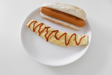 Simple easy breakfast of omelette and sausage served on white dish.