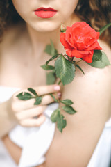 A Young Pretty Girl With Red Lipstick And Red Rose In A Hand