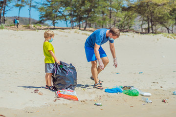 Volunteer blue face mask forest sand beach. Son helps father hold black bag for pick up garbage....