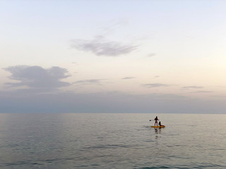 A young couple on a paddling-board in the coastal water of Benidorm-Spain.