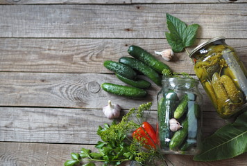 The process of canning cucumbers in glass jars under lids for storage for the winter.Ingredients for pickling cucumbers on a wooden background. Place for text.
