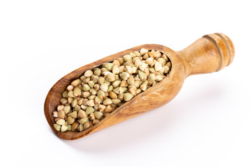 Raw buckwheat and wooden spoon on white background.