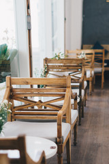 Furniture decoration in empty on people cafe bar restaurant retro modern style during second wave coronavirus quarantine city lockdown. Wood tables and chairs in sunny day. Coffee shop interior design