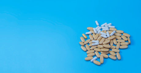 Herbal pills with healthy medical plant on blue background