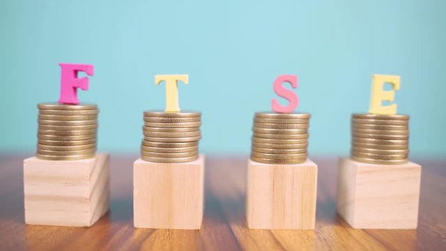 Concept of FTSE or Financial Times Stock Exchange showing with coins and letters.