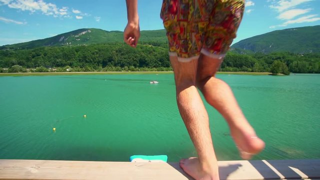 SLOW MOTION. Water jumping ballon in lake by the mountains. Catapulting a person, landing on the water balloon.