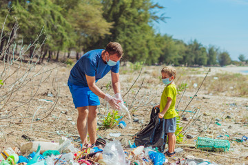Volunteer blue face mask forest sand beach. Son helps father hold black bag for pick up garbage....