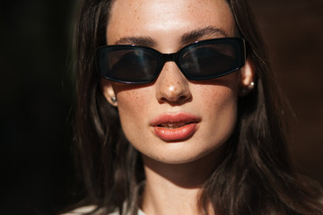 Naklejka premium Woman posing outdoors wearing sunglasses