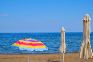 Bright raindow colored sun umbrella on the sea coast on a clear sunny day