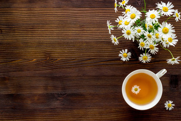 Mug of chamomile tea with fresh flowers top view