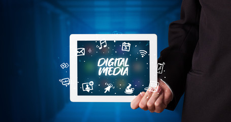 Young business person working on tablet and shows the inscription: DIGITAL MEDIA