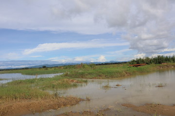 The landscape of coastal rural areas. Tidal waters with blue skies and vast green fields