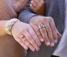 Newly wed couple's hands with wedding rings.