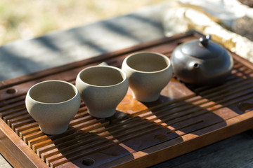 Chinese tea ceremony. Ceramic teapot made of clay and bowls on a wooden background.