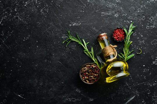 Jar of olive oil with spices on a dark background. Top view. Free space for your text.