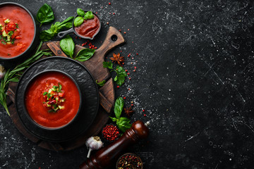 Food. Tomato Gaspacho Soup on a black stone plate. Top view. Free space for your text.