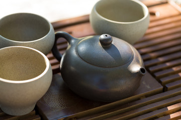 Chinese tea ceremony. Ceramic teapot made of clay and bowls on a wooden background.