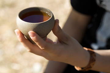Ceramic bowls made of clay on a wooden background. .The girl is drinking Chinese tea.