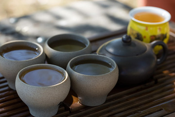 Chinese tea ceremony. Ceramic teapot made of clay and bowls on a wooden background.