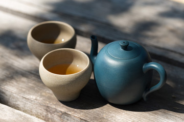 Chinese tea ceremony. Ceramic teapot made of clay and bowls on a wooden background.