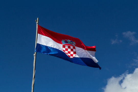 Waving croation flag before blue sky with cloud