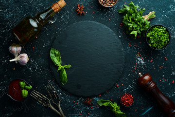 Black culinary background with spices and vegetables on the table. Top view. Free space for your text.
