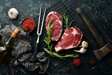 Raw meat, beef steak on dark background. Top view. Free space for your text.
