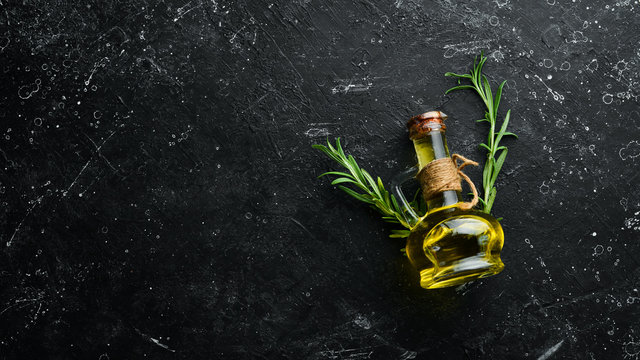 Jar of olive oil with spices on a dark background. Top view. Free space for your text.