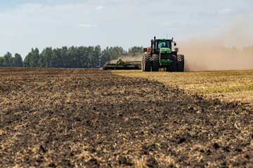 Fototapeta premium The tractor plows the land. Agriculture image
