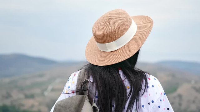 Panning shot of joyful travel girl in straw hat and sunglasses admiring nature. 4k Dragon RED camera