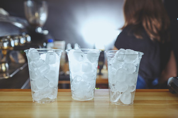 Bartender wearing medical latex black gloves, making mojito cocktail.Pieces of ice,ingredient for cooling drinks in bar.Blurred image, selective focus