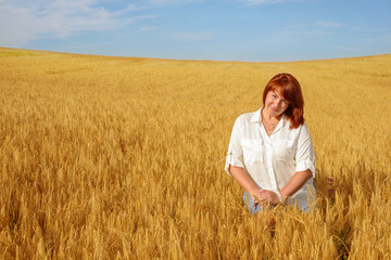 Naklejka na ściany i meble redhead woman in wheat field