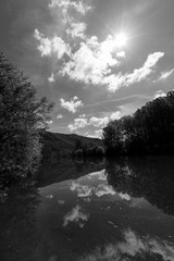 Fototapeta premium River Tarn in Ambialet French Country Side Photo in Bright Tones with Gorgeous Trees and Flowing Background Wallpaper Black and White Monochrome
