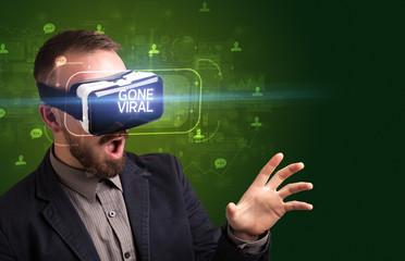 Businessman looking through Virtual Reality glasses with GONE VIRAL inscription, social networking concept