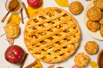 autumn baking concept with seasonal apples and cinnamon honey. Apple pie, muffins, cupcakes . top view on a light background with autumn yellow leaves.