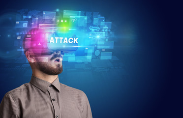 Businessman looking through Virtual Reality glasses with ATTACK inscription, innovative security concept