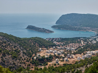 Fototapeta na wymiar Village on the pine-covered mountain range slope and island at the Mediterranean sea