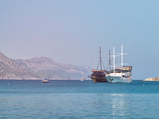Fototapeta na wymiar Nautical cruise yachts in the Mediterranean sea bay. Marine recreational cruise vessels in the sunny afternoon