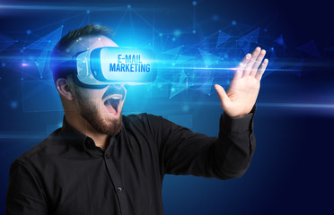 Businessman looking through Virtual Reality glasses with E-MAIL MARKETING inscription, cyber security concept